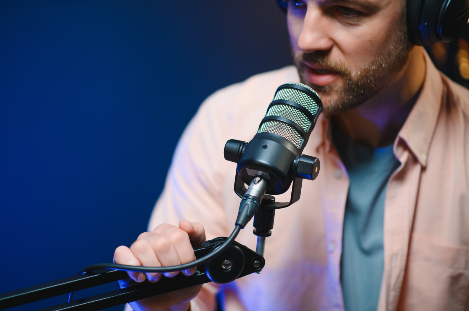 Uśmiechnięty mężczyzna nagrywający podcast przy mikrofonie