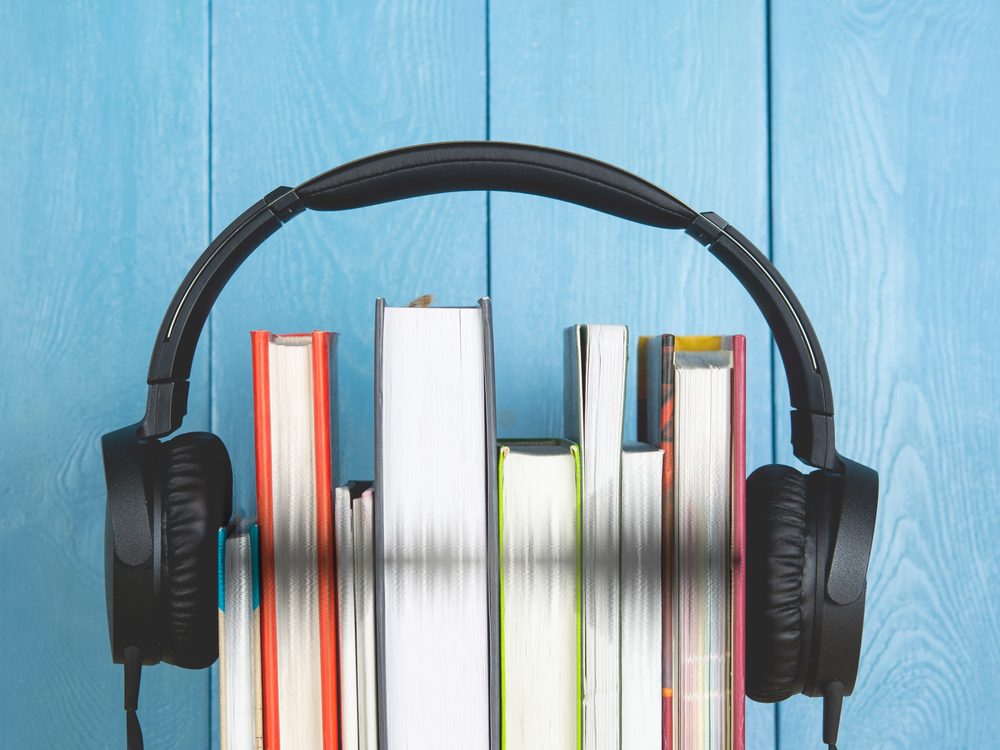 A stack of books with headphones on top — an audiobook ready to listen to